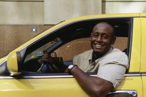 Cab driver leaning out of his yellow cab